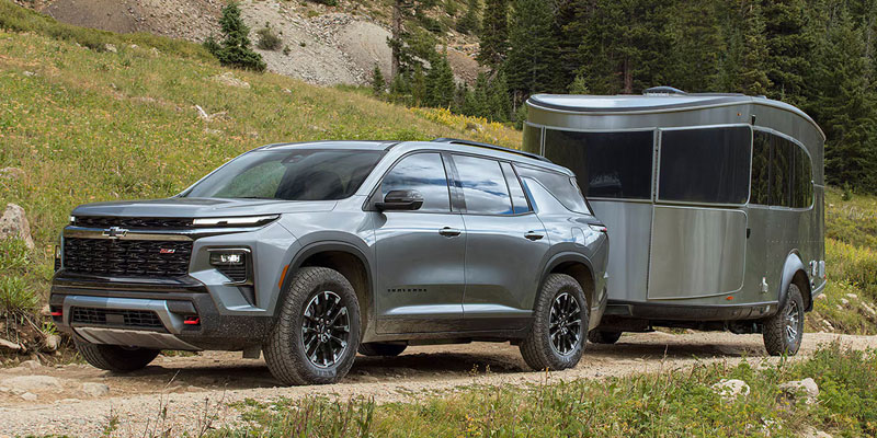 The 2026 Chevrolet Traverse is seen towing a camper, demonstrating its strength and suitability for outdoor adventures.